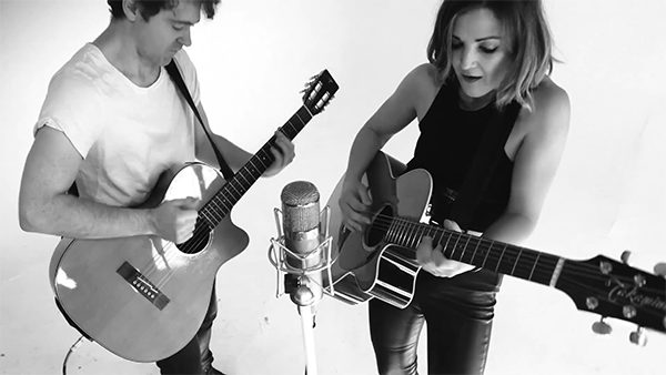 Justin and Sarah playing guitar in black and white